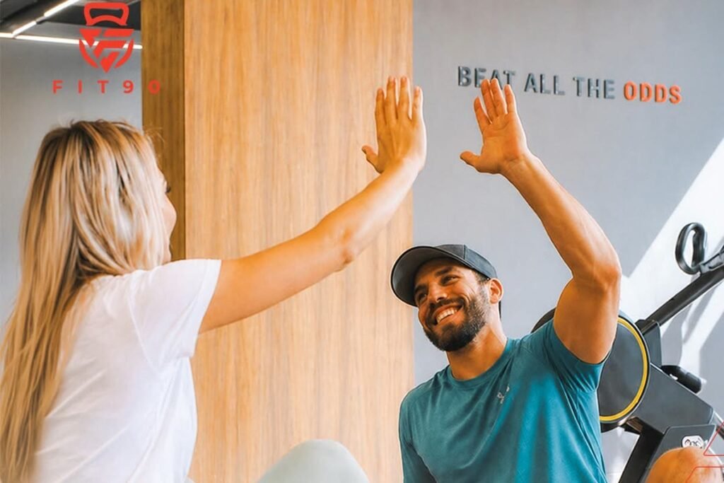 Two Fit90 members high-fiving after a session on the training floor in San Stefano, Alexandria