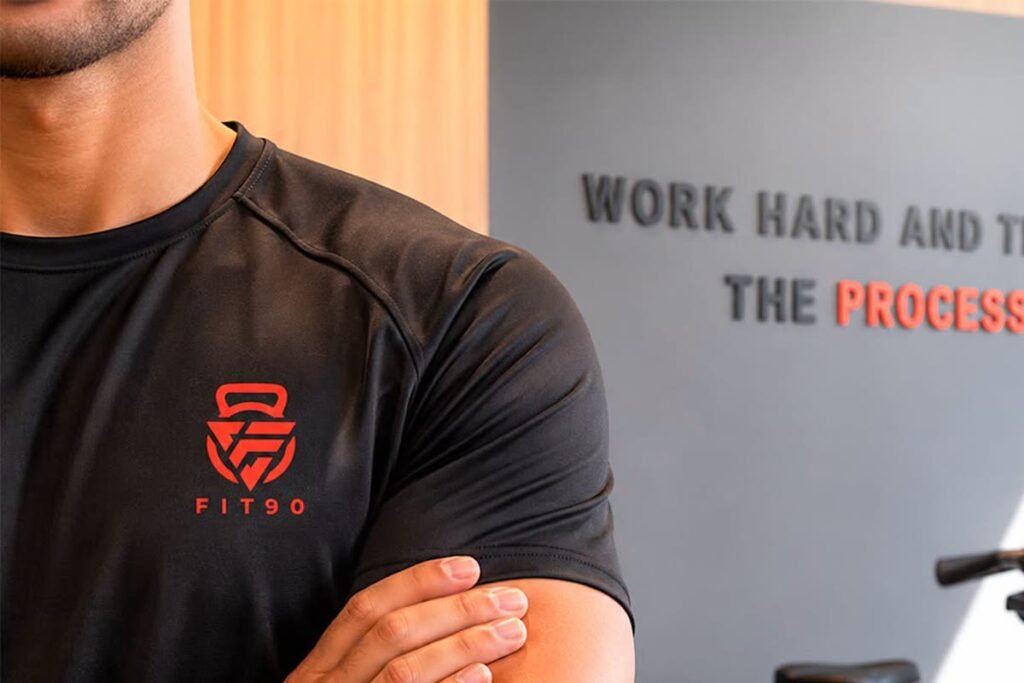 A Fit90 coach in branded kit on the gym floor in San Stefano, Alexandria