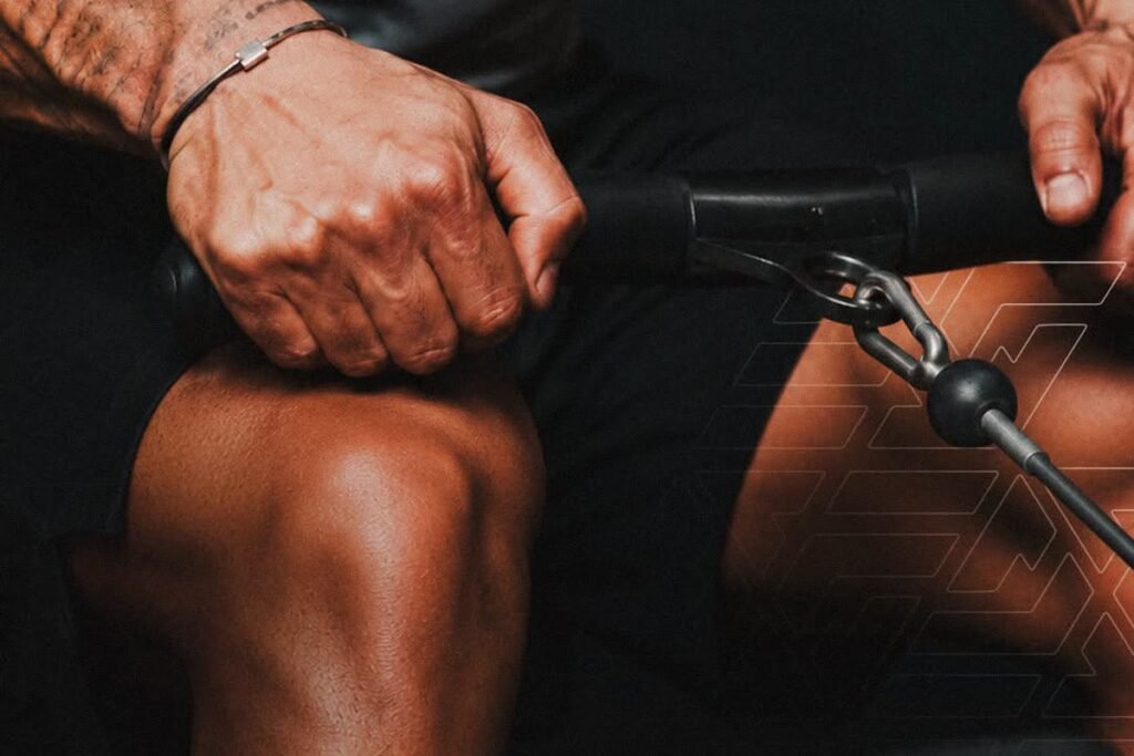 Close-up of a Fit90 member gripping a cable machine handle during a hard summer session